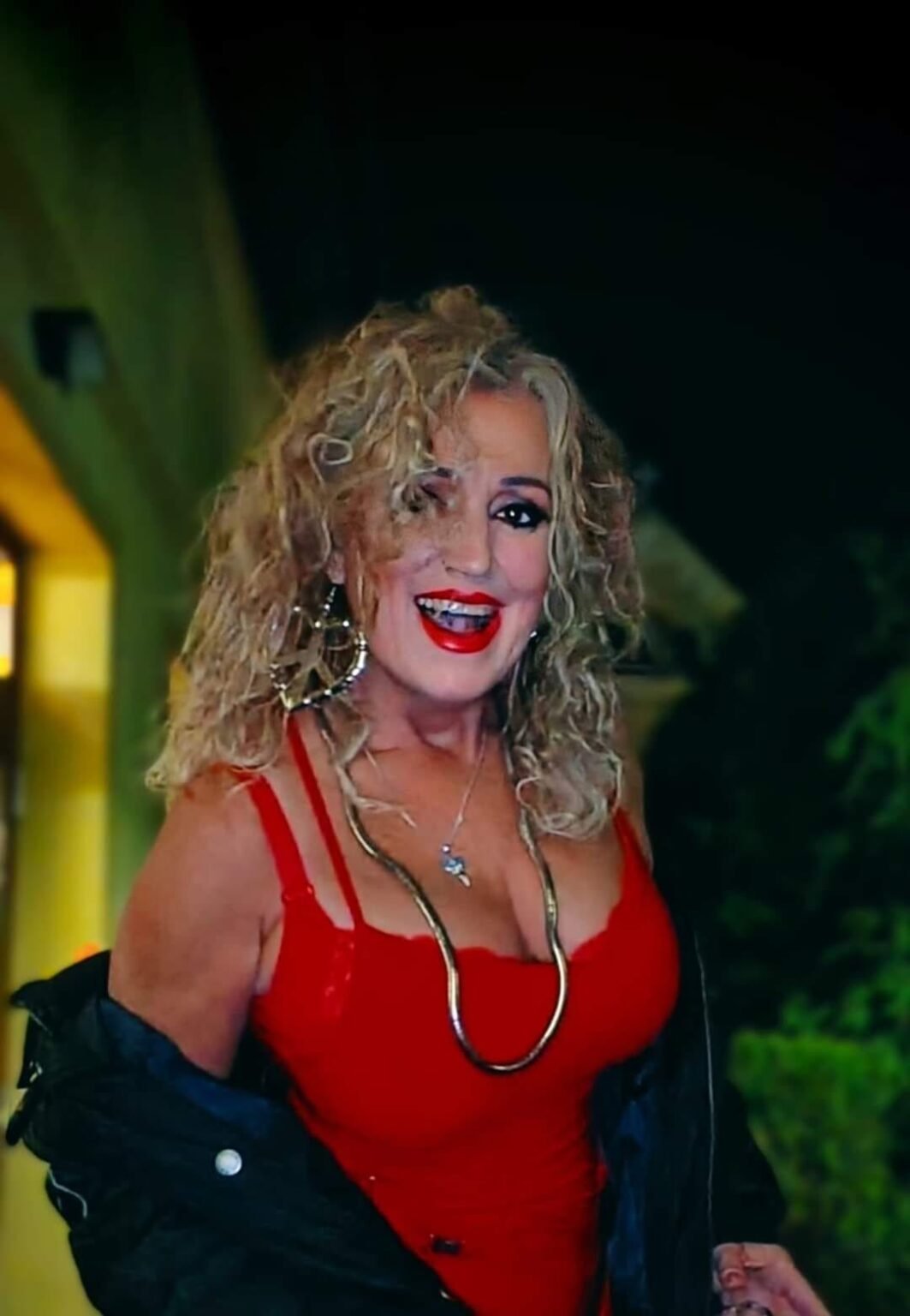 Gyurász Ildikó, a RITMO zenekar énekesnője portréfotón, piros ruhában, esti fényben